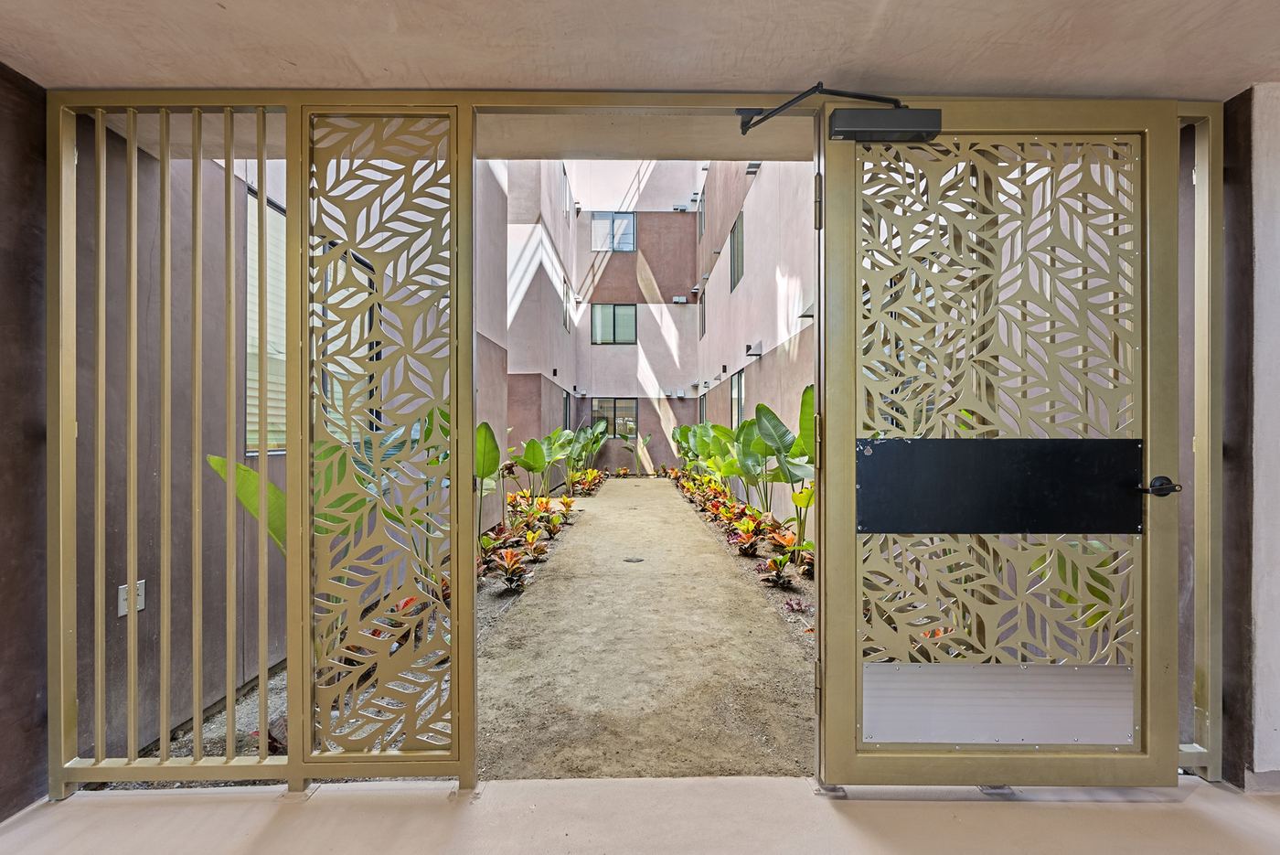 The gate to the courtyard, seen from inside the entry. A metal gate with a cut leaf pattern.